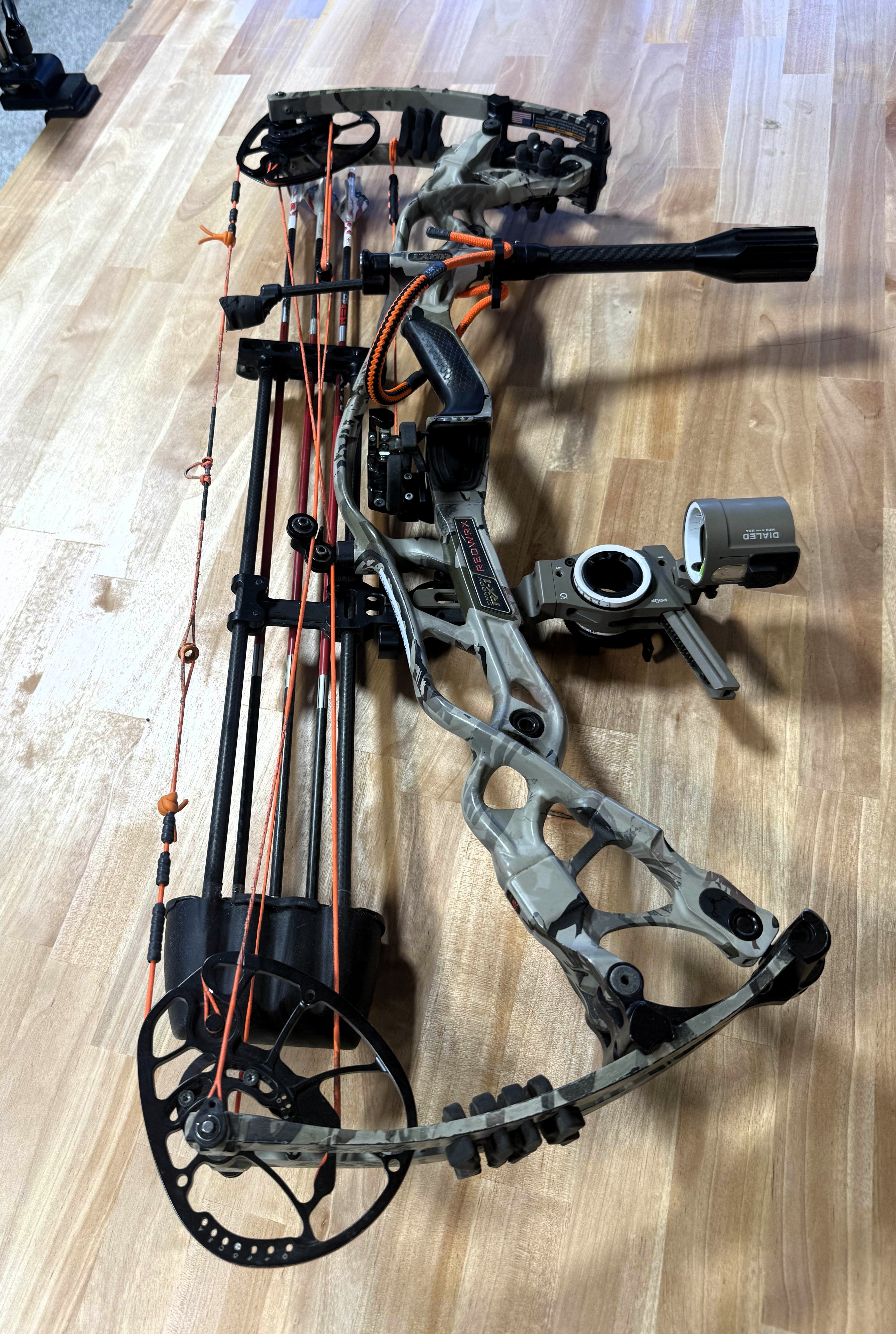 compound archery bow resting on a wooden workbench